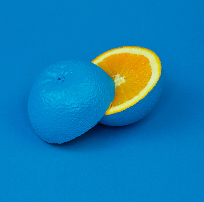 Blue Orange Cut in Half against Blue Background 